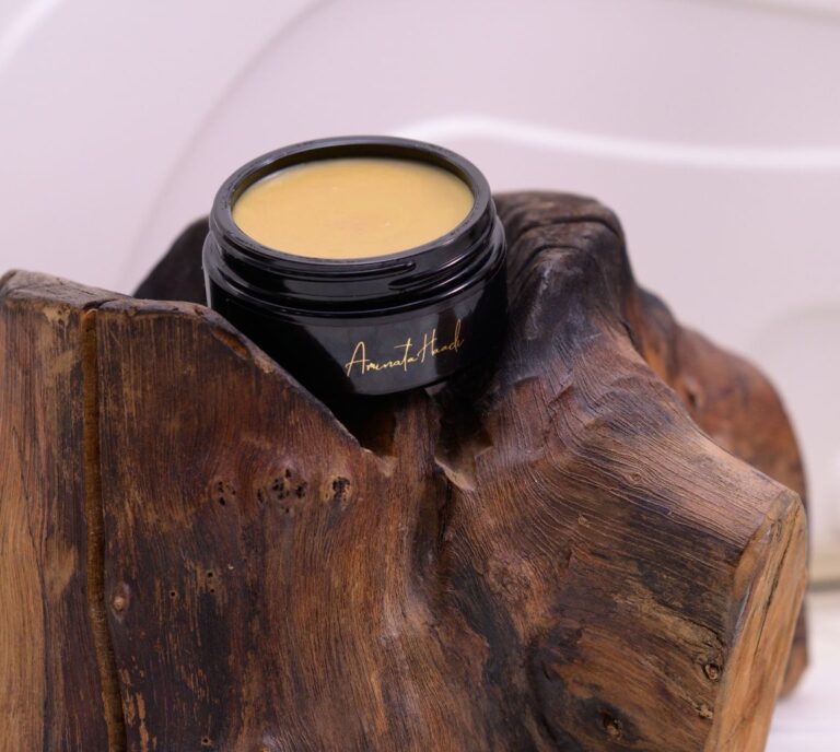 A luxurious jar of Felis Ethnobody Butter lip balm elegantly placed on a polished wooden block.