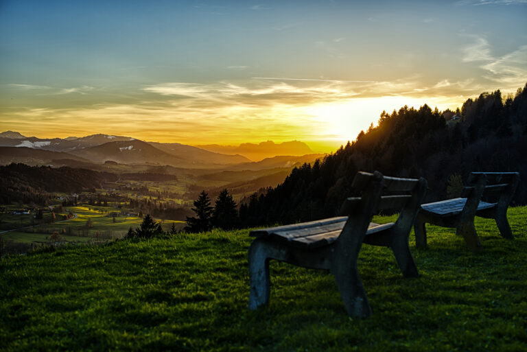Two outdoor benches facing the alps of Switzerland.
