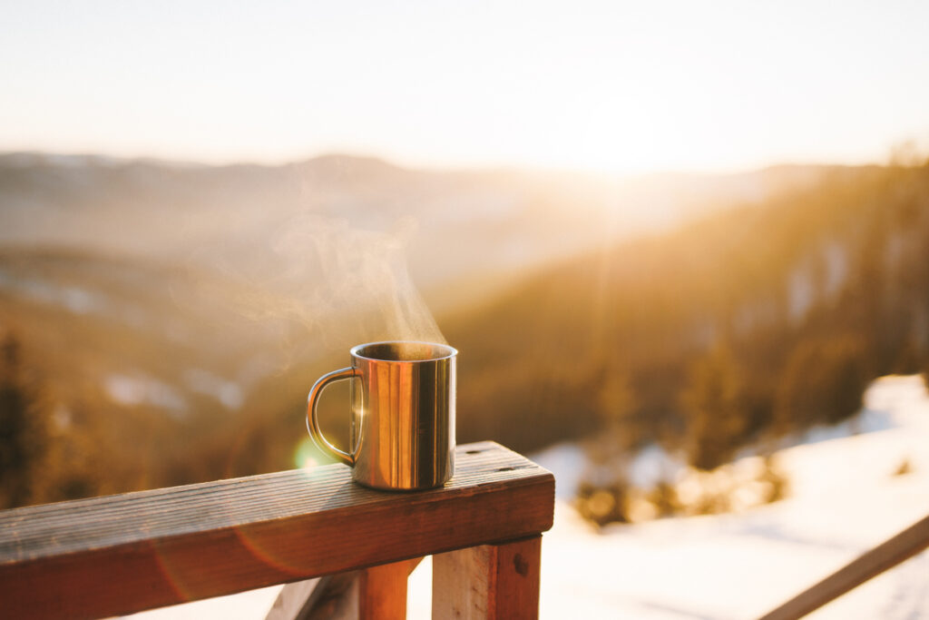 Cup of joe on outdoor deck, facing the mountains. 