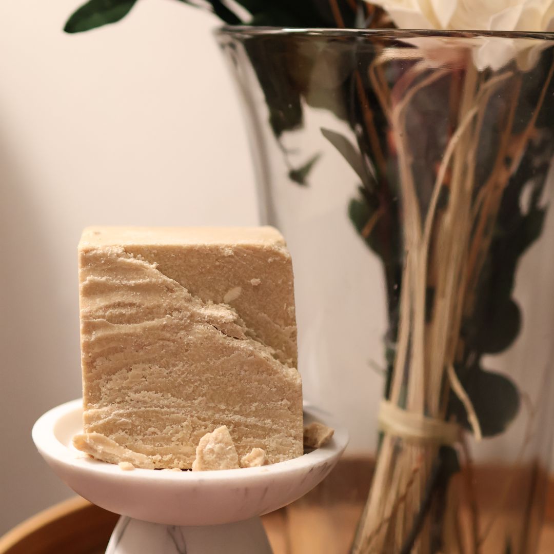 Ethnobotanical skincare. Wild-harvested kokum butter beside dried florals.
