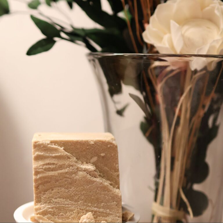 Ethnobotanical skincare. Wild-harvested kokum butter beside dried florals.