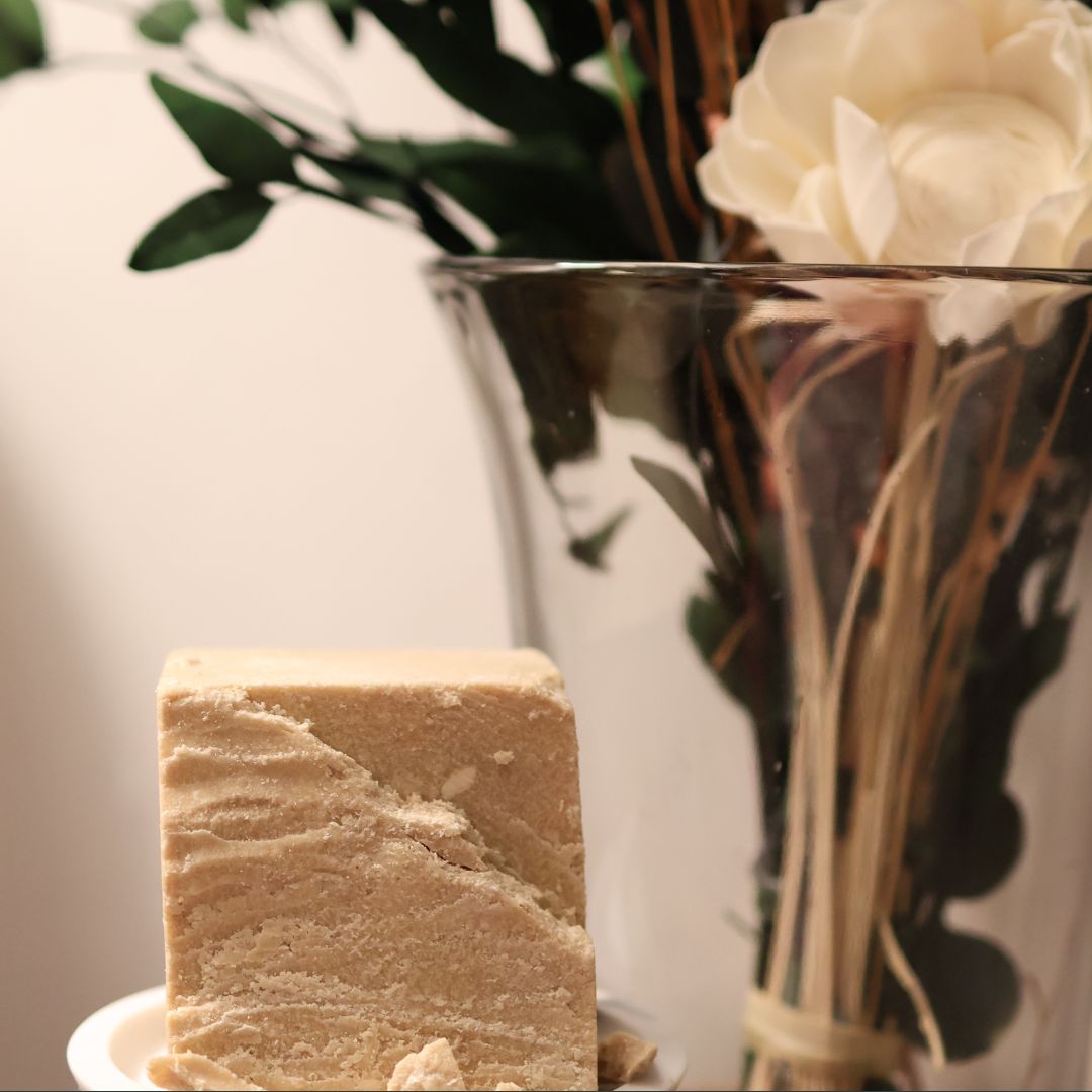 Ethnobotanical skincare. Wild-harvested kokum butter beside dried florals.